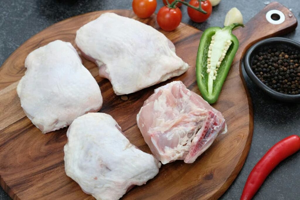 Presas de pollo fresco sobre tabla